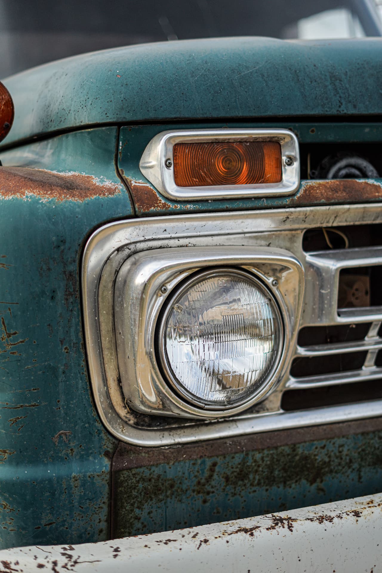 Chrome and rust on the front of a vintage teal truck