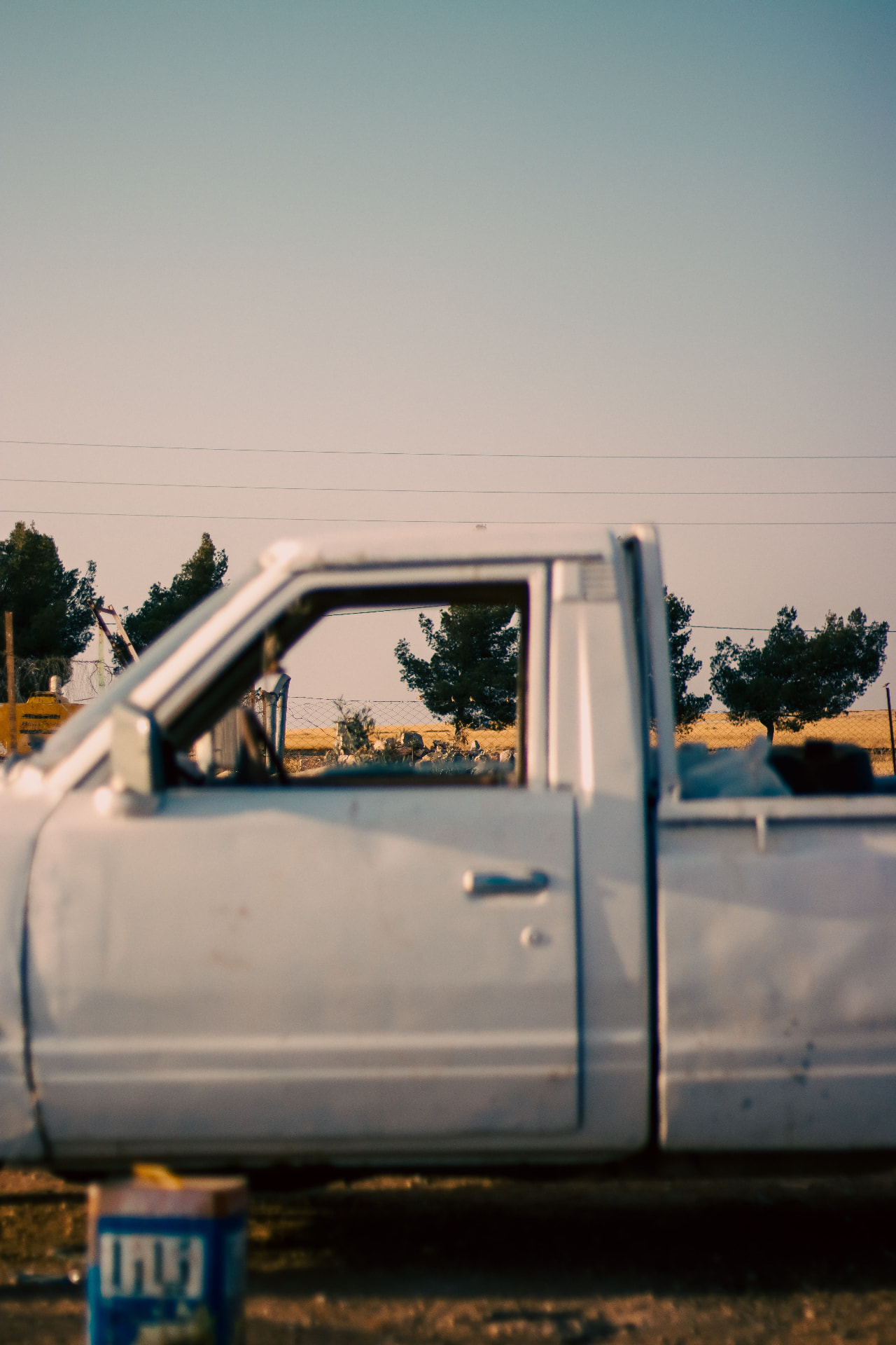 White vintage pickup truck in a field at sunset